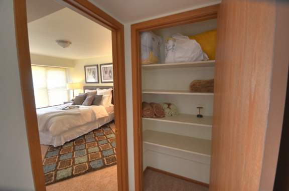a bedroom with a closet with shelves and a bed
