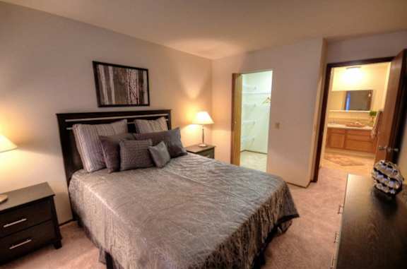 a bedroom with a large bed and a bathroom