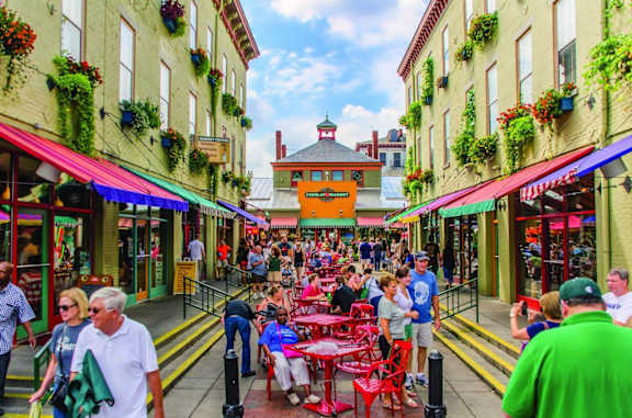 A busy street scene with people dining at tables outside restaurants.at Sky Central, Cincinnati