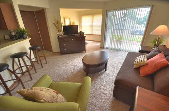 a living room with a couch and a chair and a tv