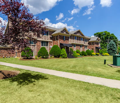 a large brick house with a tree in front of it