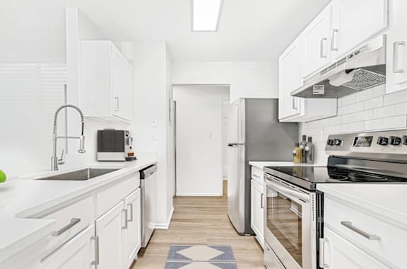 A modern kitchen with white cabinets and stainless steel appliances. at Bridges at Mallard Creek Apartment Homes, Charlotte, NC, 28269