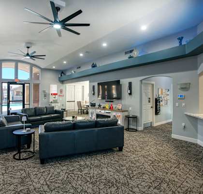A spacious living room with a grey carpet and furniture.