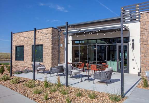 A modern building with a patio area in front.