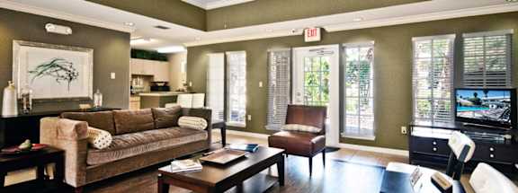 A living room with a brown couch and a coffee table.