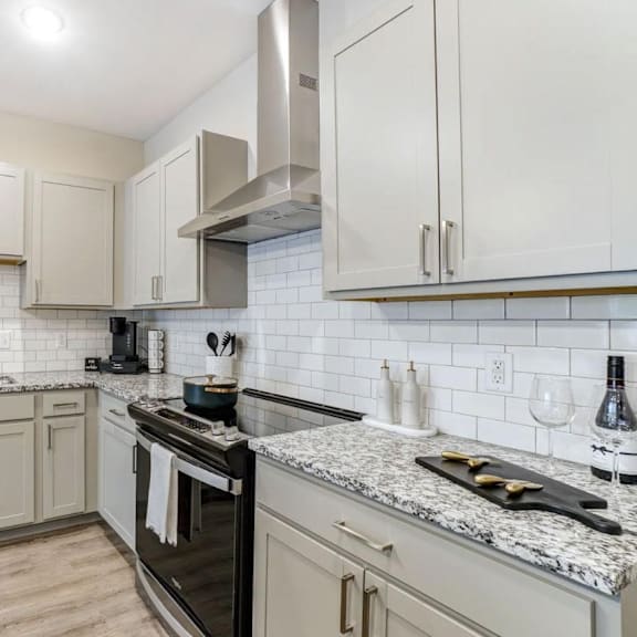 A kitchen with a stove, sink, and cabinets. at Eden Forest Townhomes Apartments, Kentwood , 49508