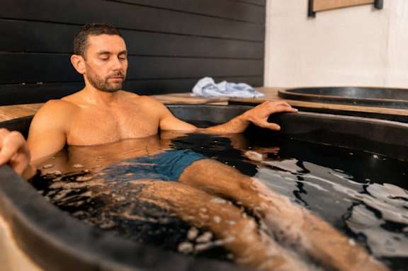 A man is sitting in a hot tub.