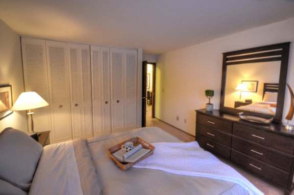 a bedroom with a bed and a dresser and a mirror