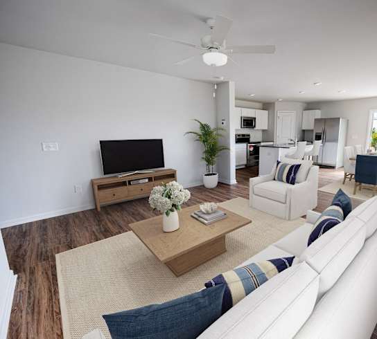 a living room with white furniture and a tv
