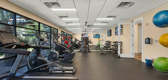 A gym with treadmills, exercise bikes, and weights.