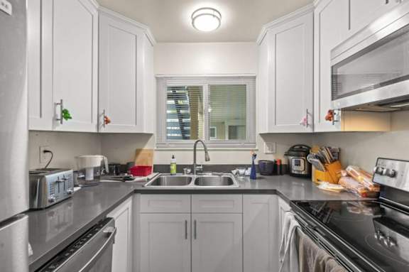 a kitchen with white cabinets and a sink