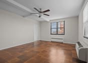 Thumbnail 7 of 20 - an empty living room with a ceiling fan and a window
