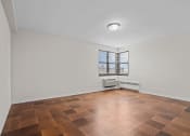 Thumbnail 12 of 20 - an empty living room with a window and wooden floors