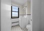 Thumbnail 9 of 20 - a white bathroom with a toilet and a window