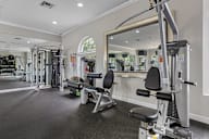 A gym with a mirror, weights, and exercise equipment.