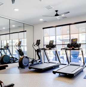 A gym with treadmills, exercise bikes, and elliptical machines.