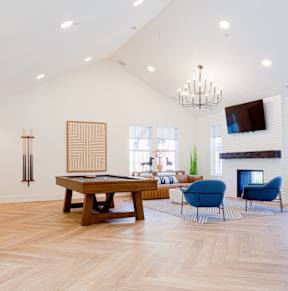 A living room with a pool table and a fireplace.