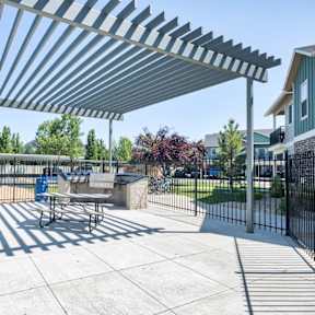 A playground with a shaded area under a metal canopy.