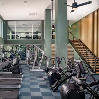 A gym with treadmills, exercise bikes, and weights.