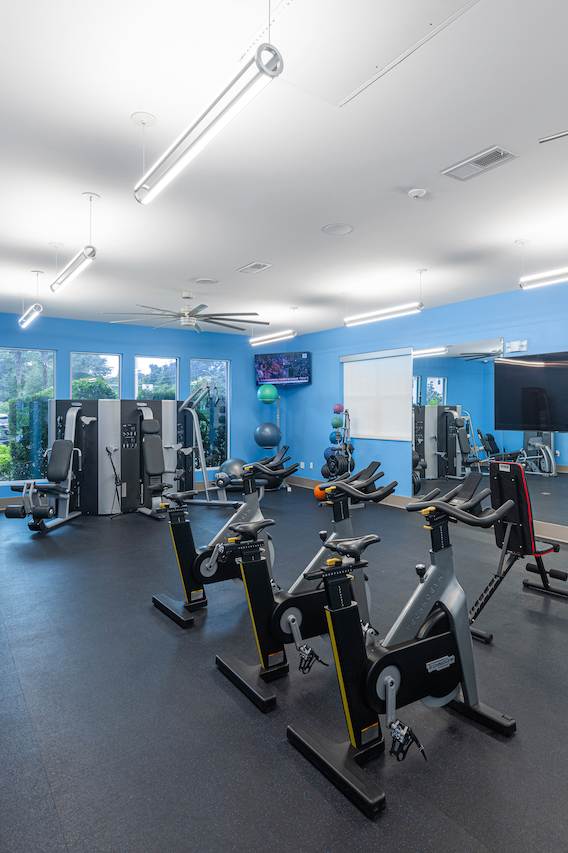 a fitness center with cardio equipment and weights in a gym