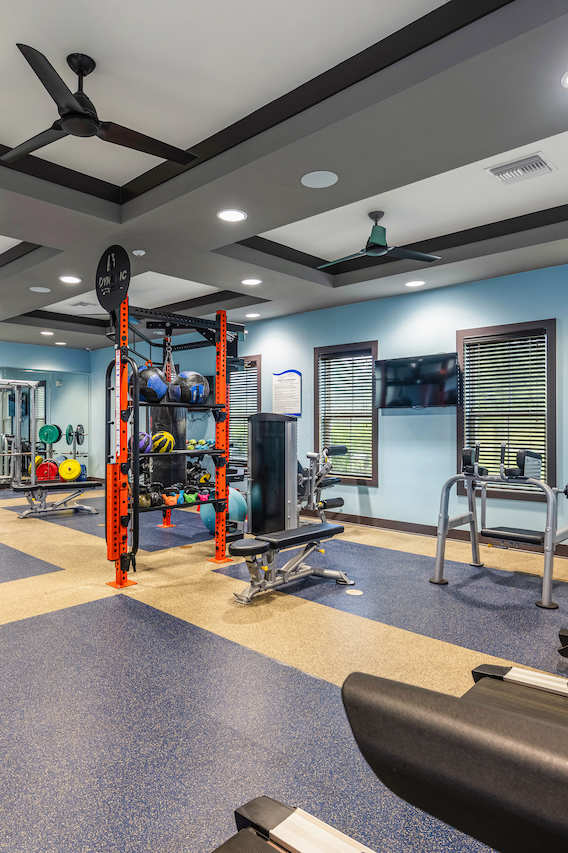 a fitness center with cardio equipment and weights in a gym