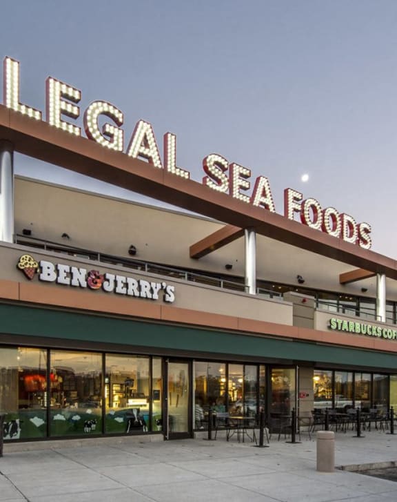 the facade of a local seafood store with tables and chairs