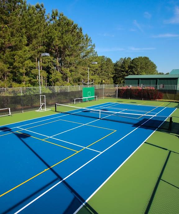 a tennis court with blue and green courts and a fence