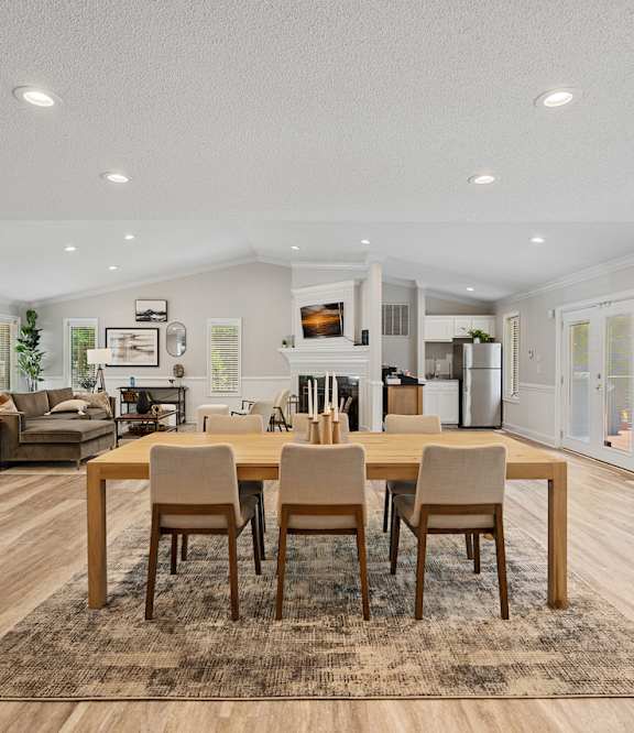 a living room with three mirrors and a wood floor