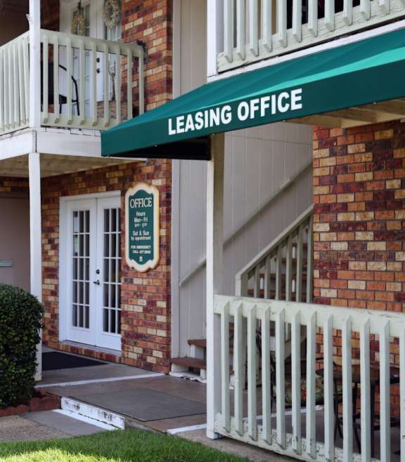 A building with a green awning that says Leasing Office.