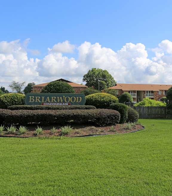 A green lawn with a sign that says Briarwood.