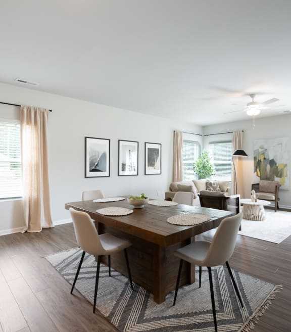 a dining room and living room with a wooden table and chairs