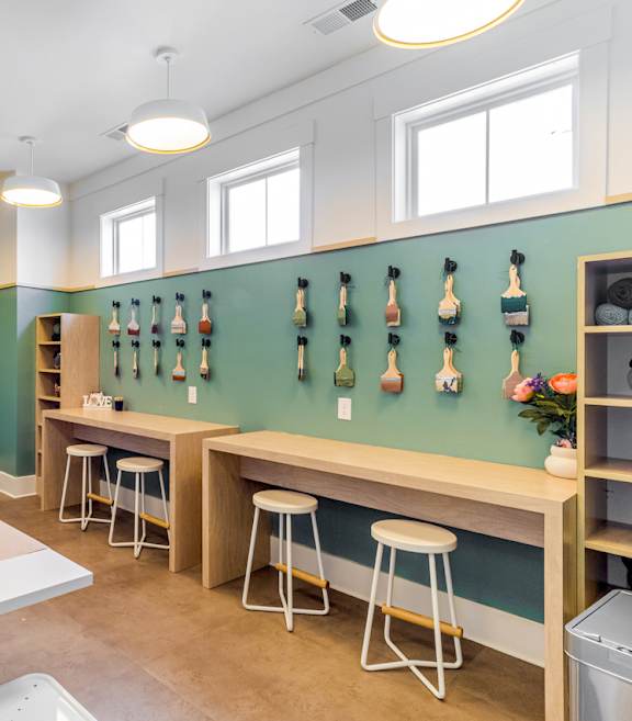 a room with tables and stools and squash rack on the wall