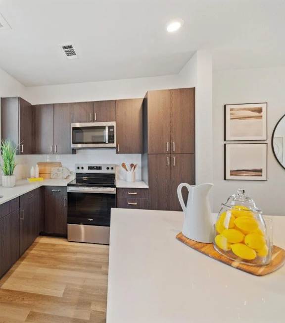 A modern kitchen with wooden cabinets and stainless steel appliances.