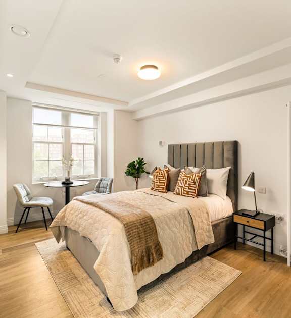 A bedroom with a large bed and a window.