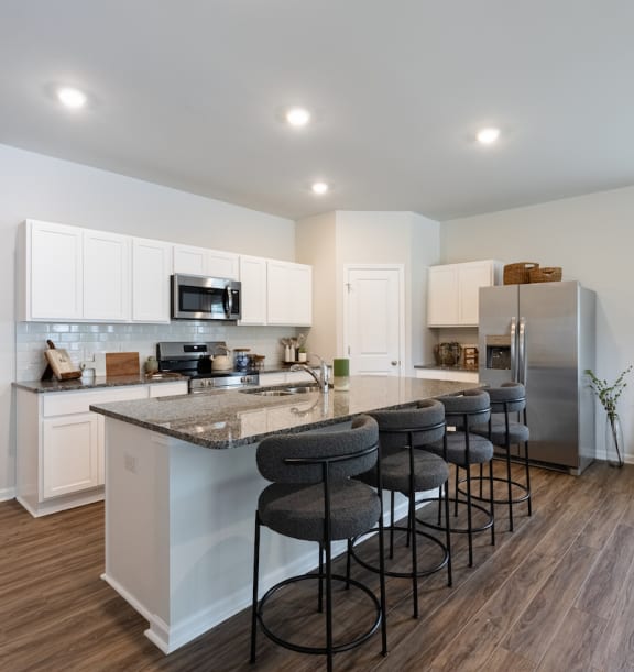 an open kitchen with a large island with bar stools