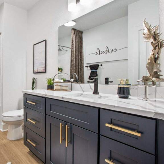A bathroom with a white toilet, a white sink, and a white countertop.