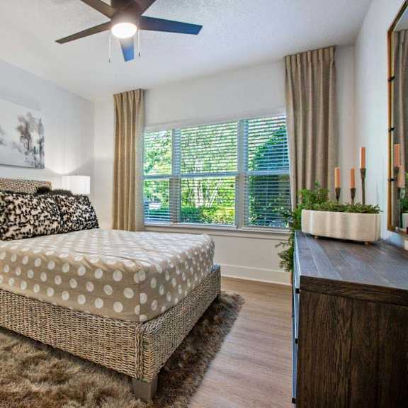 A bedroom with a bed, nightstand, and a painting on the wall.