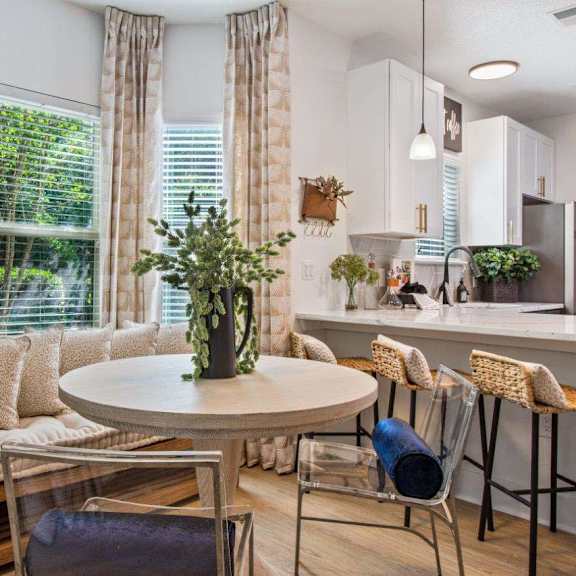 A dining area with a round table and chairs.
