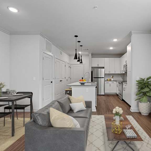 A modern living room with a grey couch and a dining table.