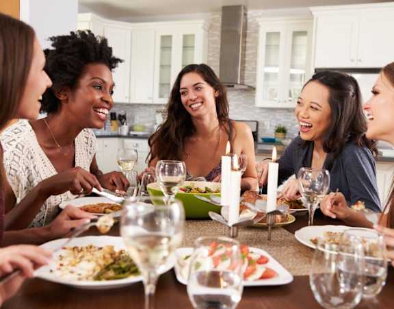 A group of women are enjoying a meal together at a table.