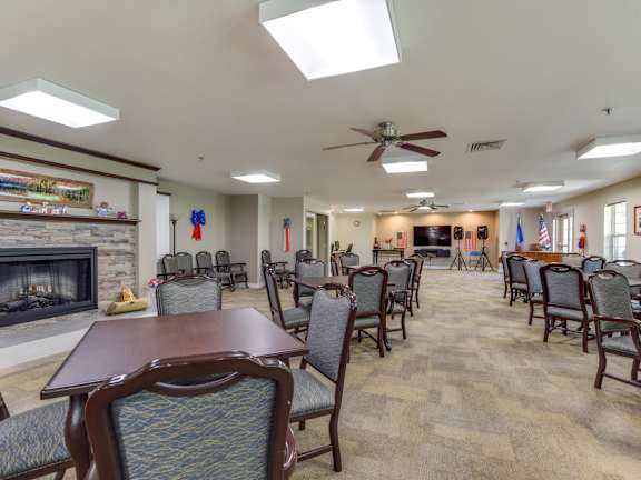 A large room with a fireplace and chairs.