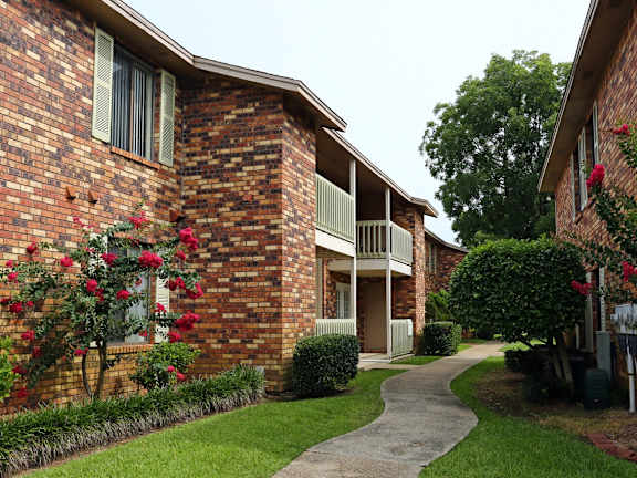 A brick building with a green lawn in front.
