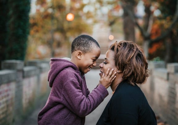 a woman whispering into a young child