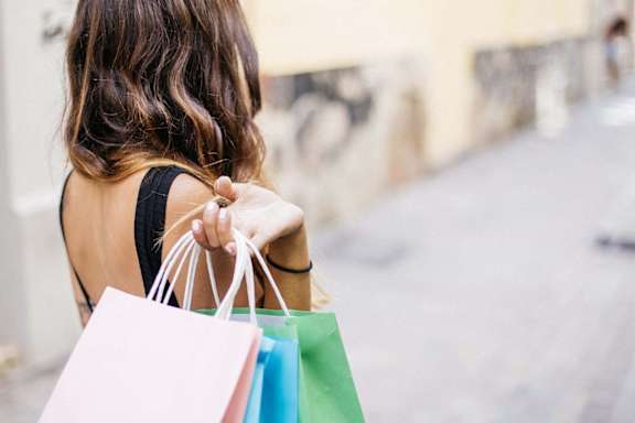 a woman carrying shopping bags and holding three shopping bags
