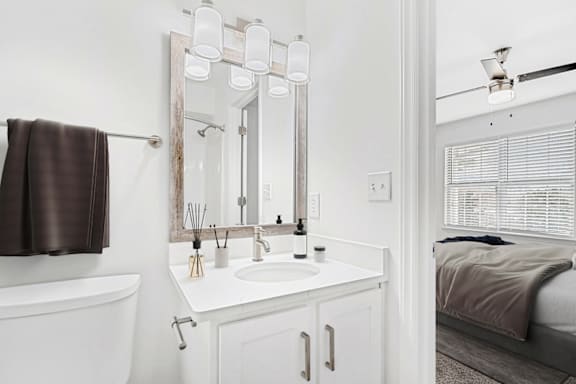 a small bathroom with a sink and a mirror at Caveness Farms Apartments, Wake Forest, NC 27587