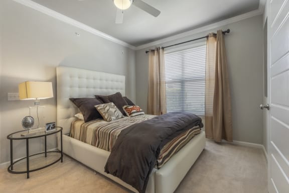staged bedroom with carpeted flooring, window, and ceiling fan
