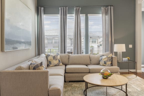 staged living room with hardwood-style flooring and windows