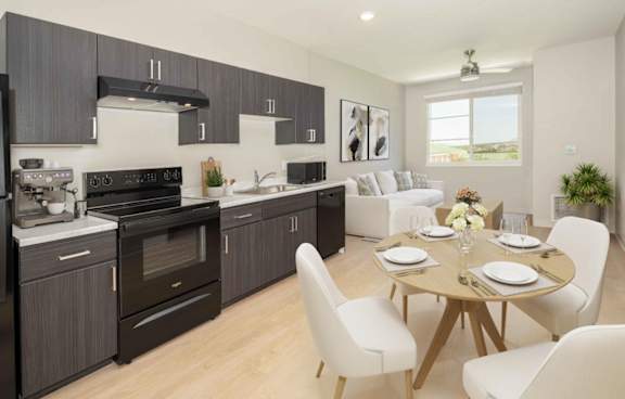A modern kitchen with a dining table set for two.