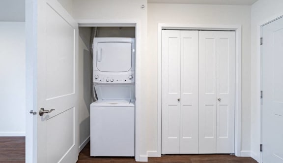 a small laundry room with a washer and dryer in it and a closet