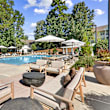 a swimming pool with lounge chairs and umbrellas at Caveness Farms Apartments, Wake Forest, NC